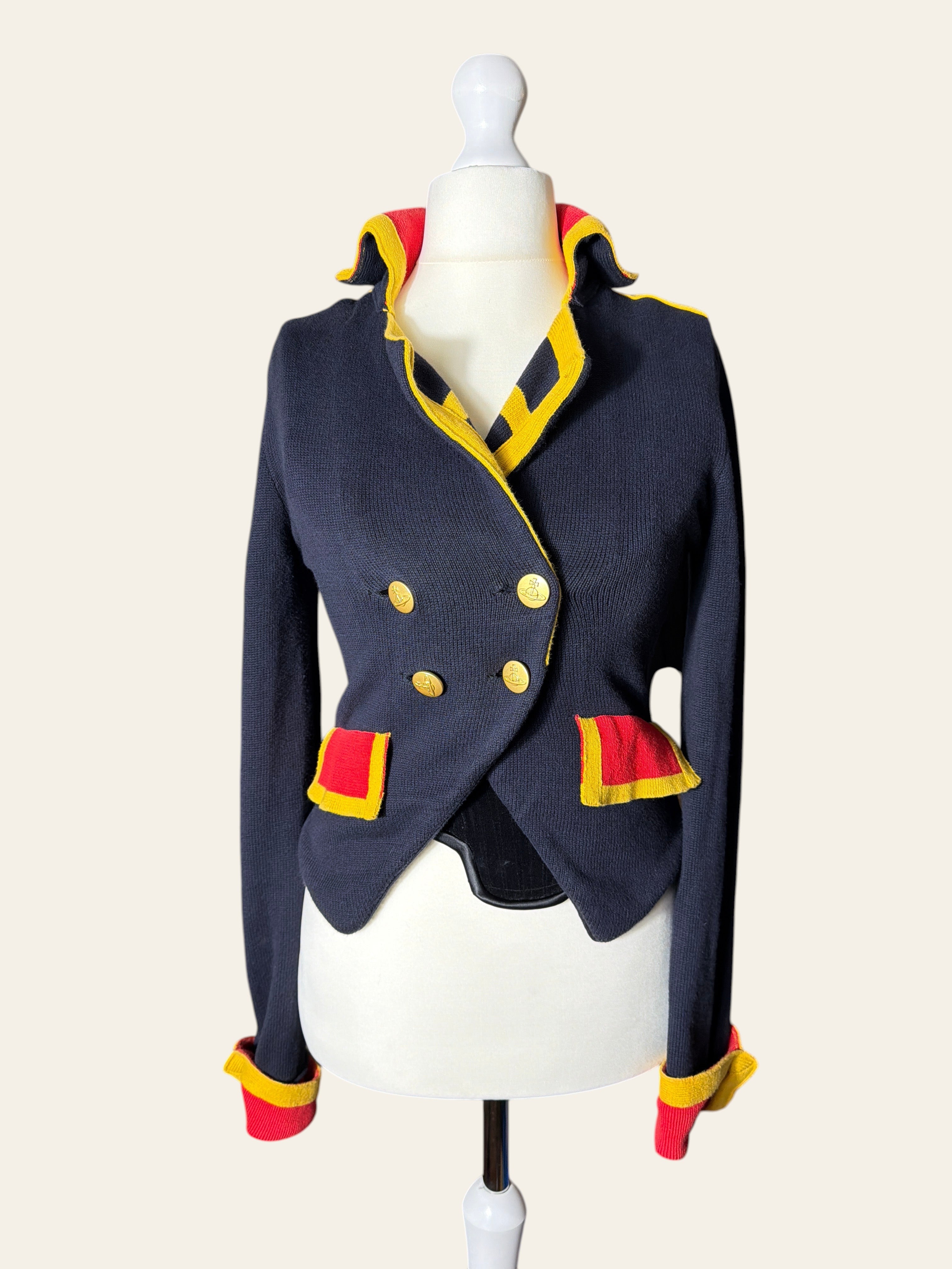 A navy blue cropped double-breasted jacket with yellow and red trim, displayed on a white mannequin torso against a light beige background.