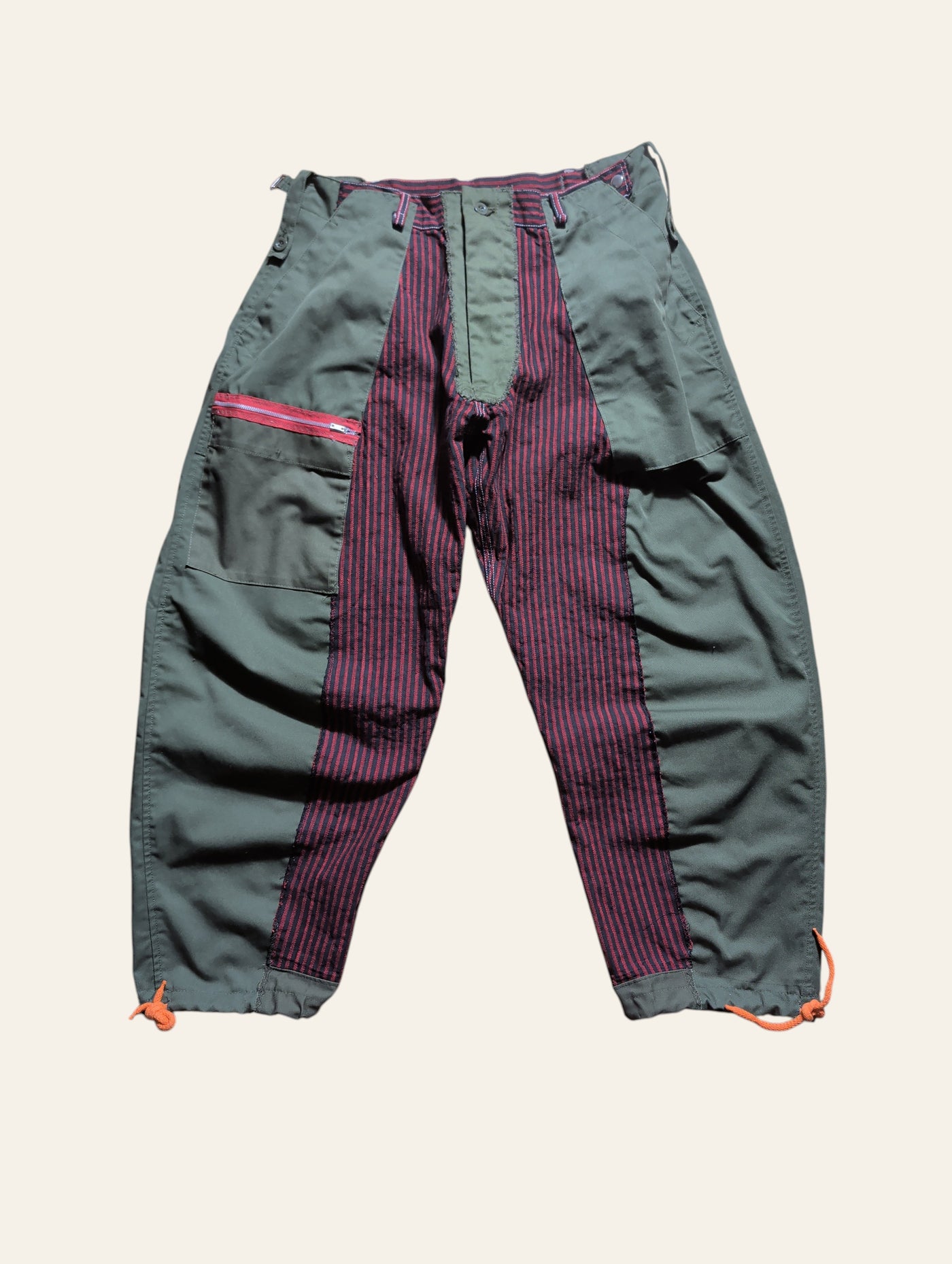 Lolly and Lotus reworked army pants featuring olive green panels and red striped fabric with a zippered pocket.
