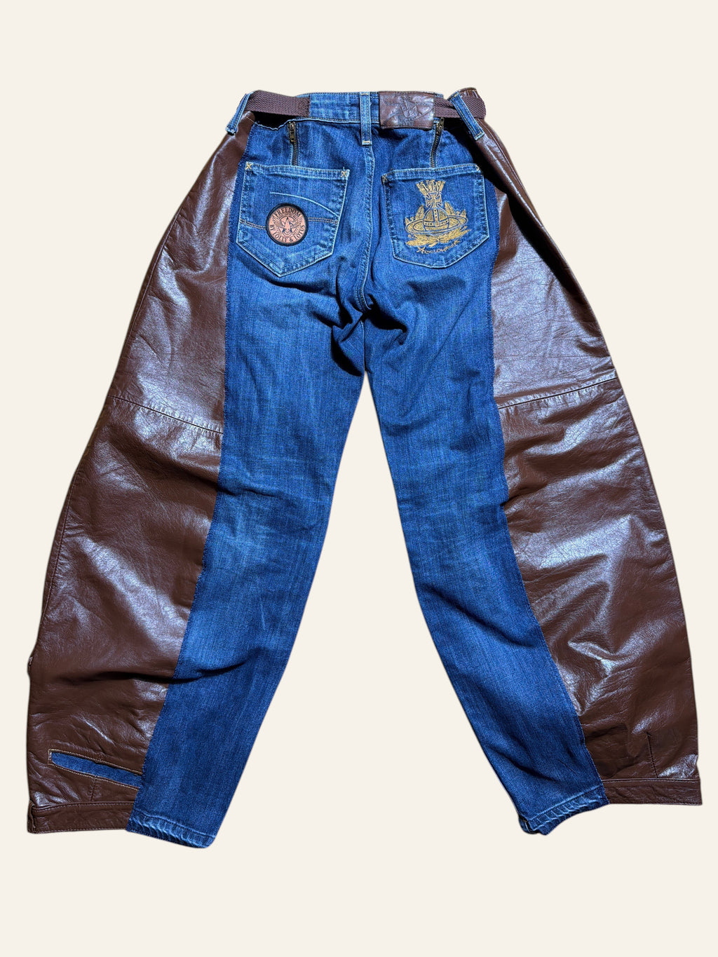 Lolly and Lotus reworked blue denim jeans with brown leather chaps, featuring an orb patch and integrated belt.