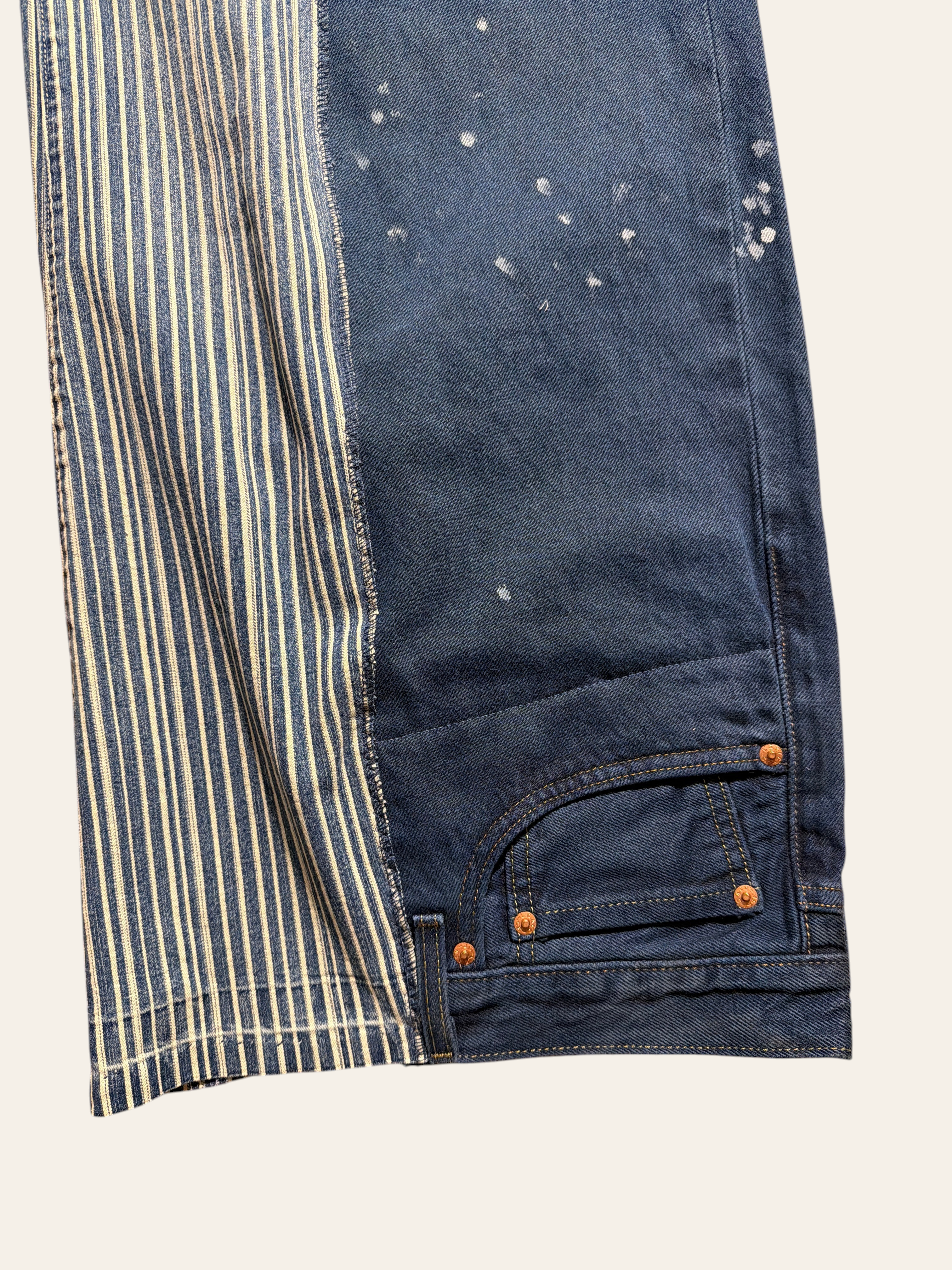 Lolly and Lotus reworked vintage Levi jeans featuring blue denim with white paint splatters and striped fabric panels.