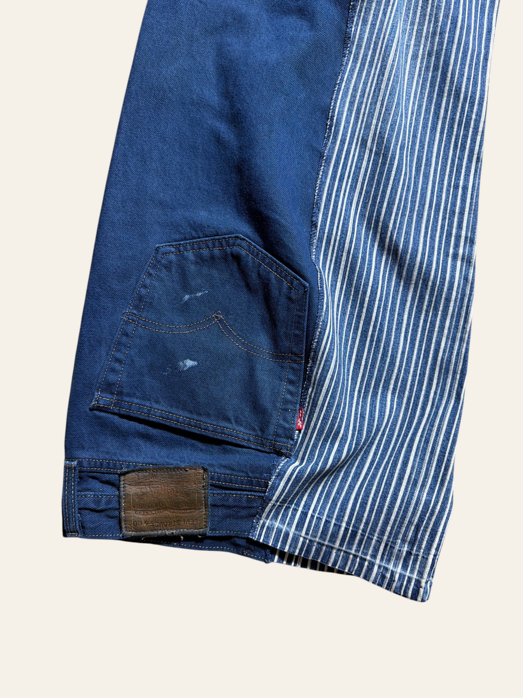 Lolly and Lotus reworked vintage Levi denim jeans featuring a blue and white striped panel and back pocket detail.