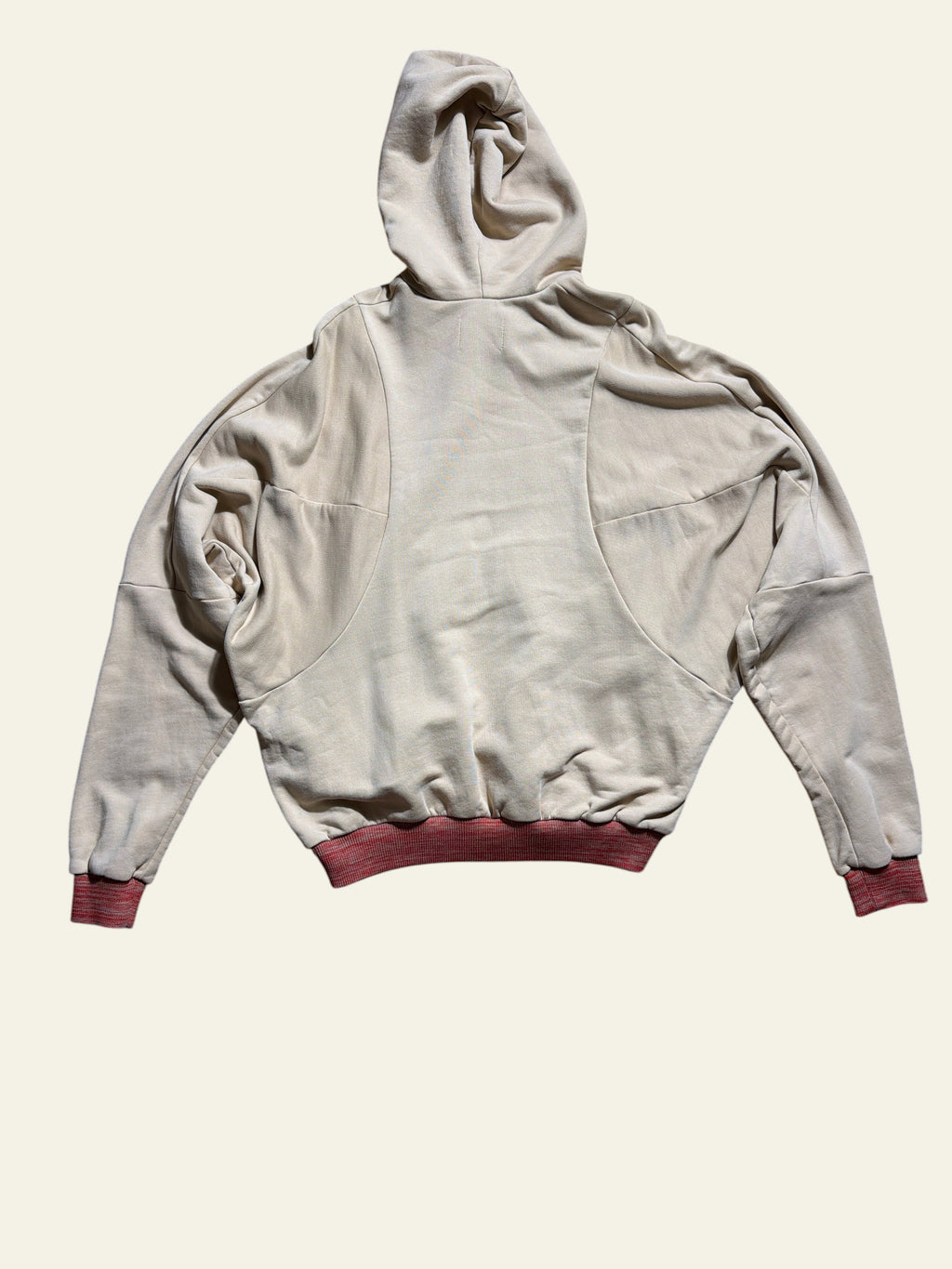 Lolly and Lotus Vivienne Westwood beige pourpoint hoodie with red ribbed cuffs, back view on wooden floor