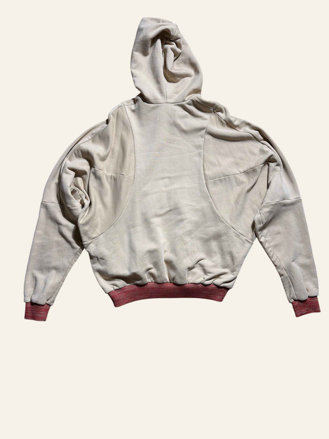 Lolly and Lotus Vivienne Westwood beige pourpoint hoodie with red ribbed cuffs, back view on wooden floor