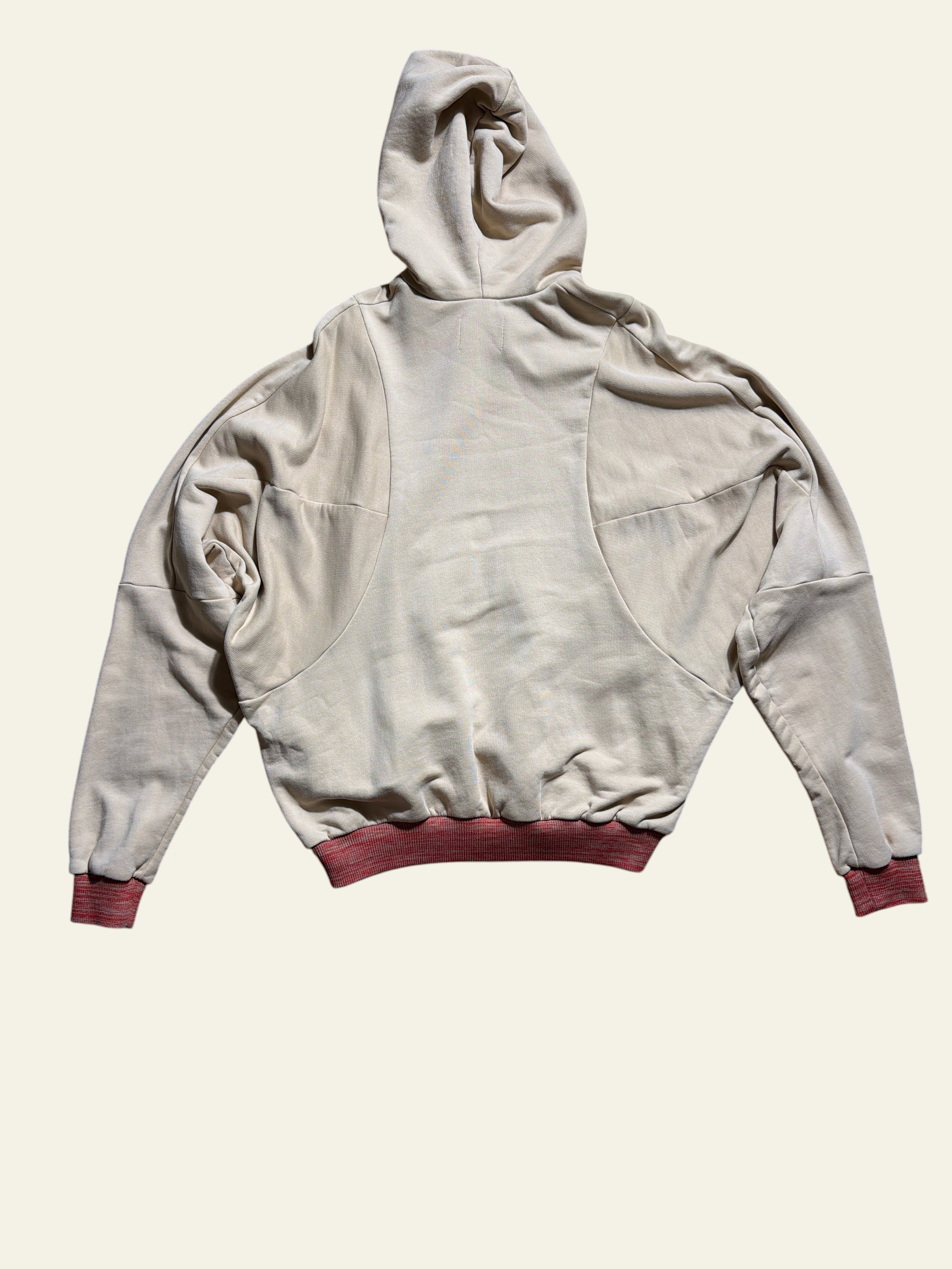 Lolly and Lotus Vivienne Westwood beige pourpoint hoodie with red ribbed cuffs, back view on wooden floor