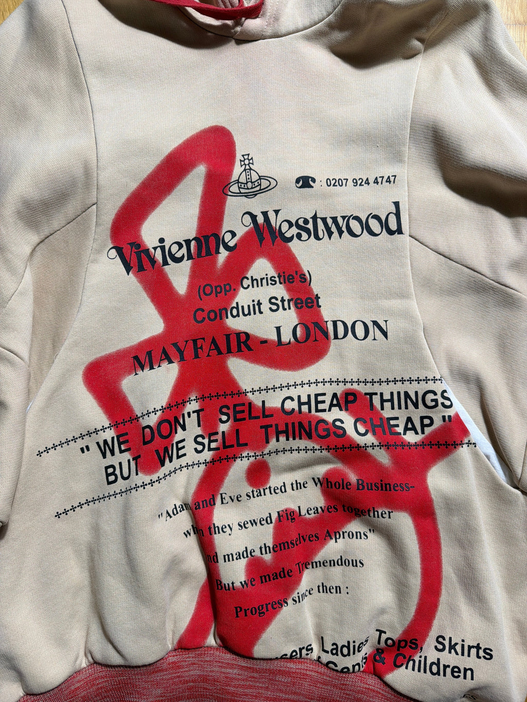Lolly and Lotus Vivienne Westwood beige hoodie with red graphic print and black text detailing on the front