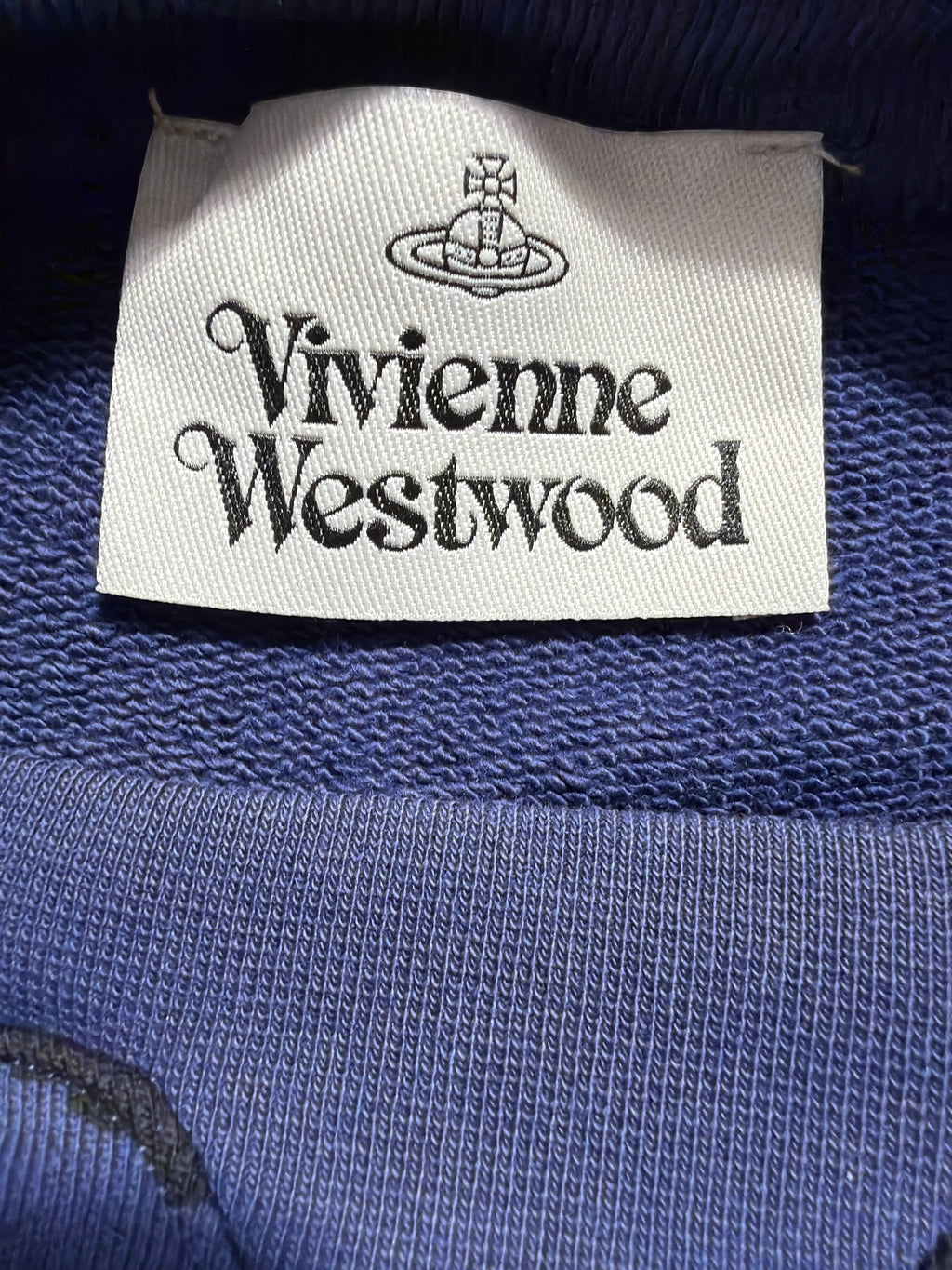 Lolly and Lotus Vivienne Westwood Chaos cropped jumper brand label on blue cotton fabric