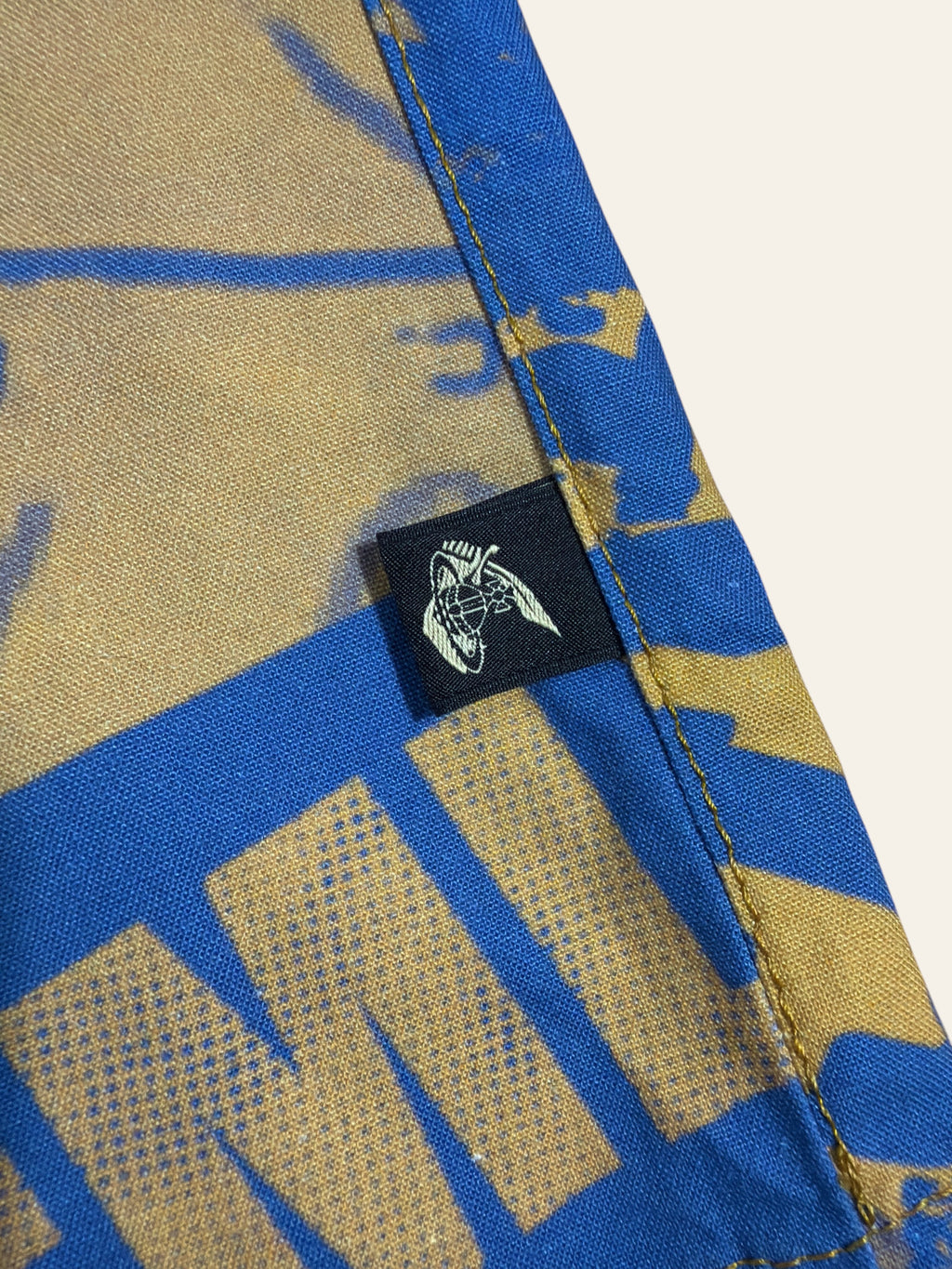Lolly and Lotus Vivienne Westwood Anglomania shirt side seam featuring the iconic orb logo tab on blue and gold fabric