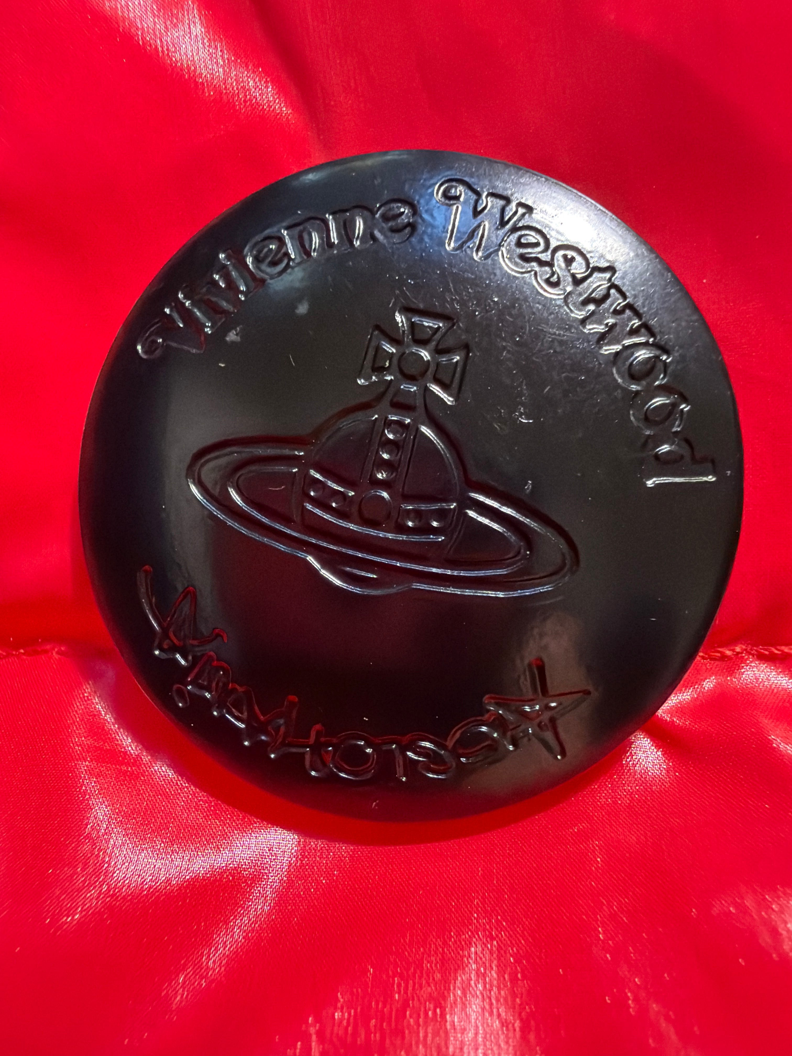 Lolly and Lotus black Vivienne Westwood puffer jacket button with embossed orb logo on a vibrant red background