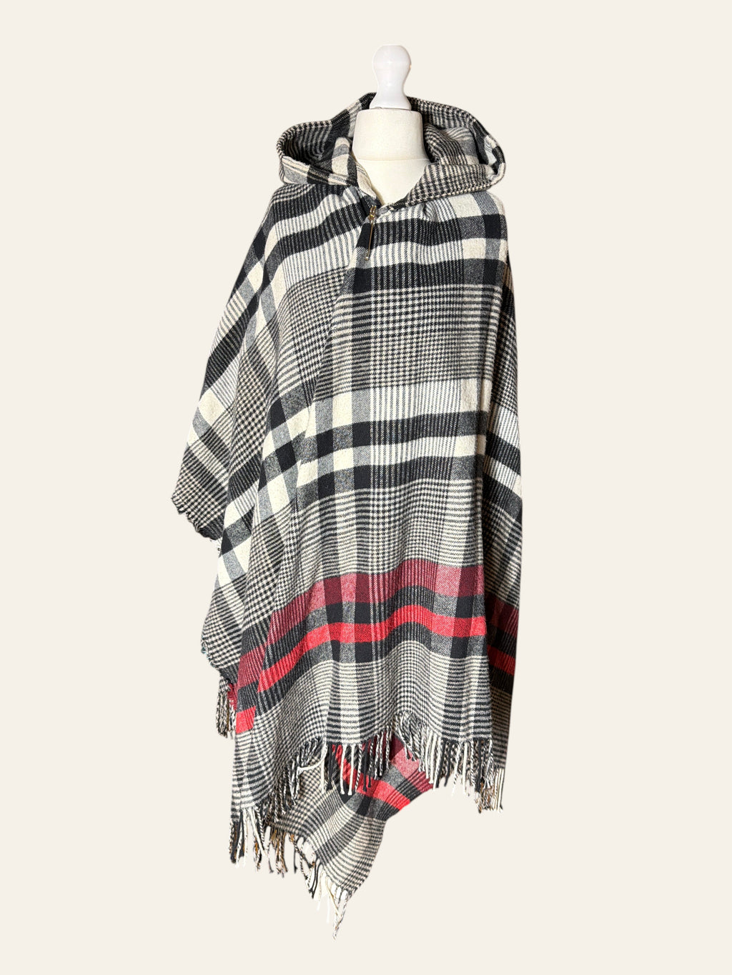 Lolly and Lotus Vivienne Westwood hooded poncho in black, cream, and red tartan with fringed edges on a mannequin.