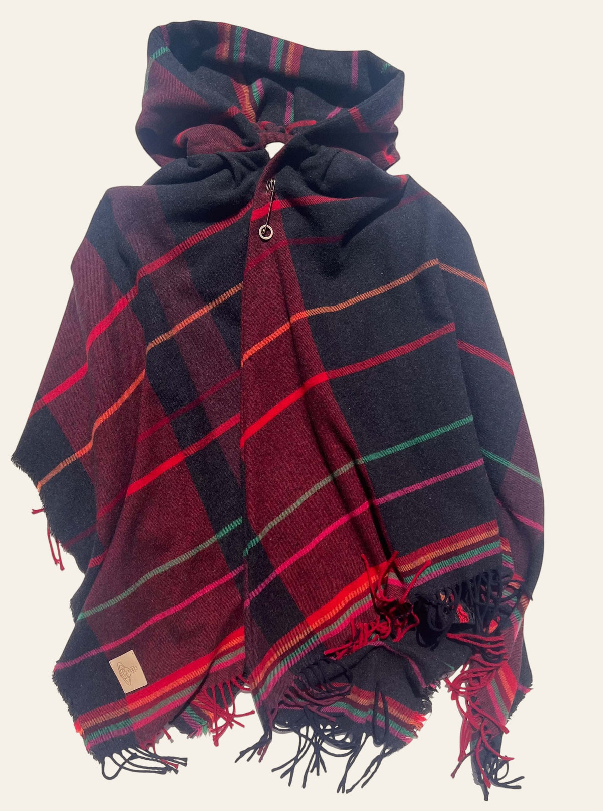 Vivienne Westwood hooded tartan poncho in burgundy, black, and red with fringe and Orb patch detail.