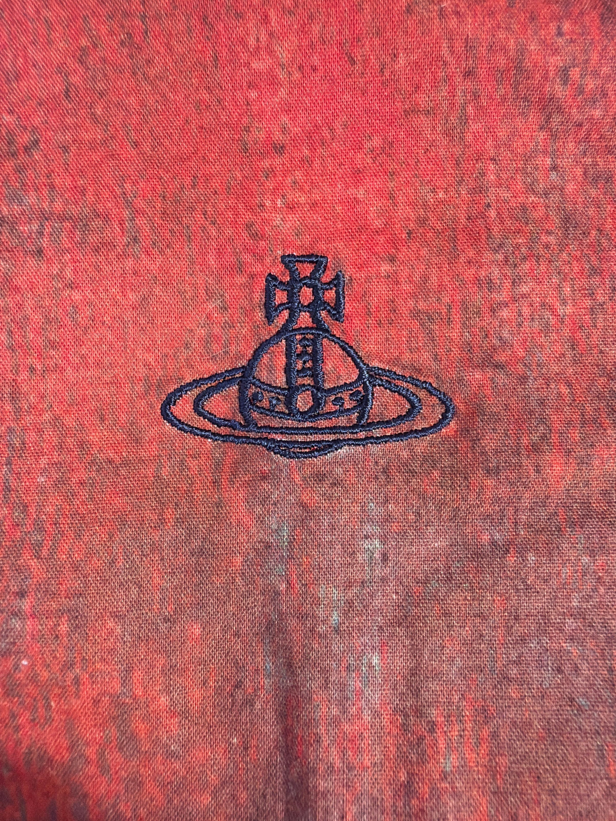 Vivienne Westwood MAN shirt featuring a dark blue embroidered Orb logo on a red abstract print fabric.