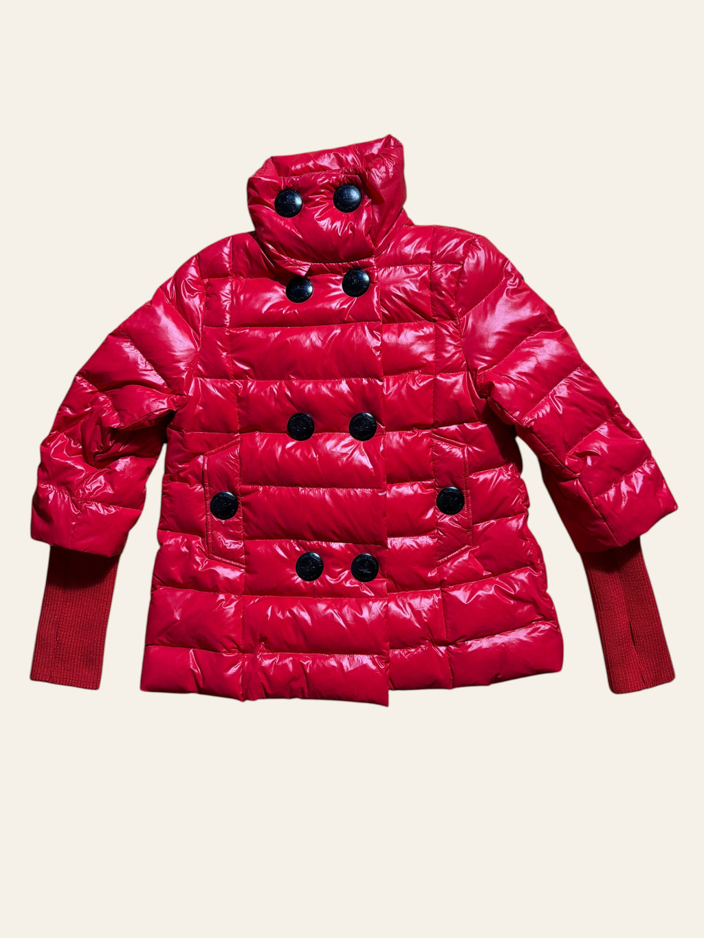 Vivienne Westwood red glossy puffer jacket with double-breasted black buttons and ribbed knit cuffs.