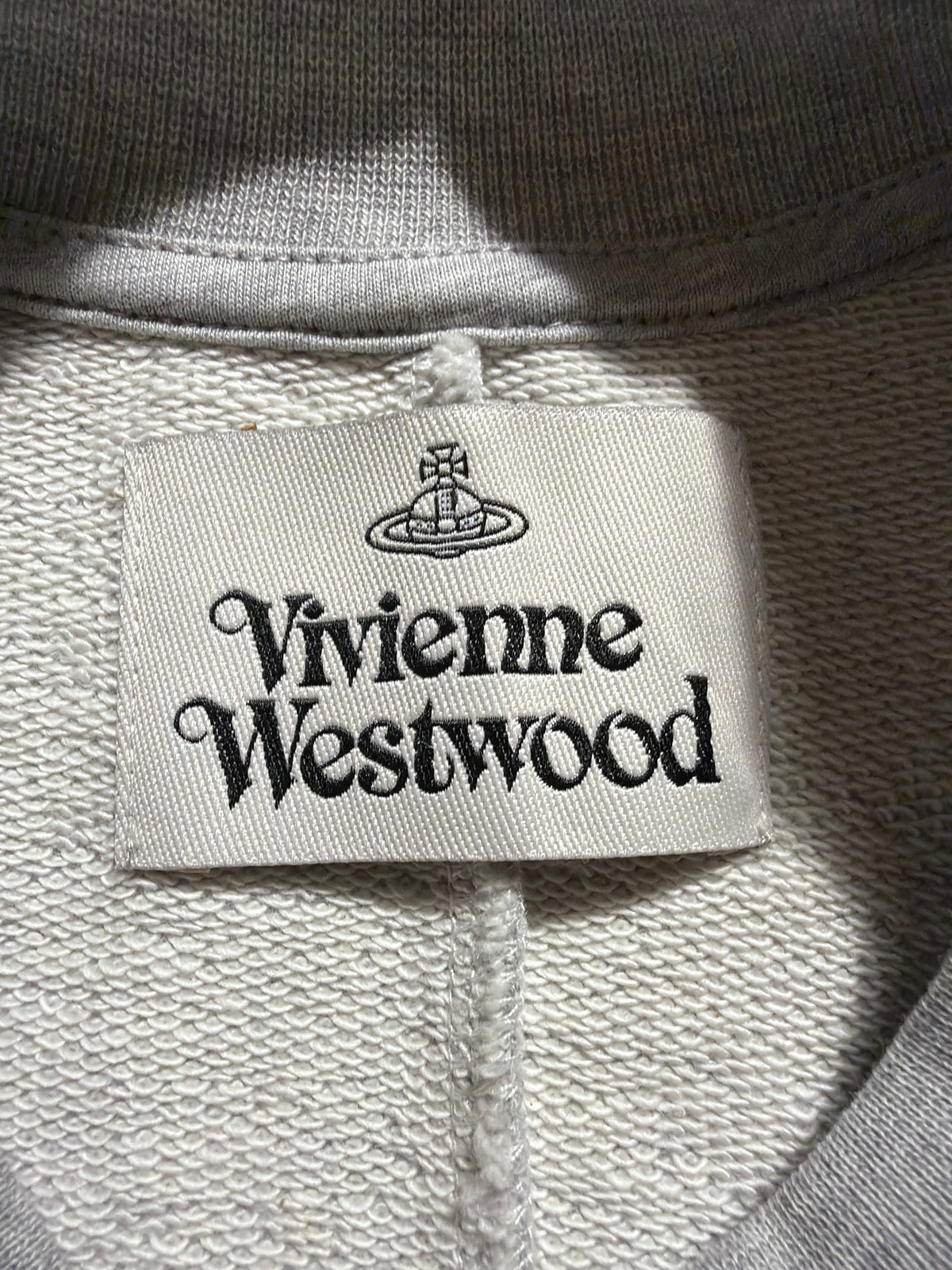 Vivienne Westwood Sunken Sander sweatshirt interior brand label and grey cotton fabric detail.